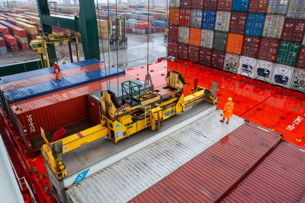 pexels photo 28438290 28438290 Aerial view of workers managing cargo loading at a bustling port with vibrant shipping containers.